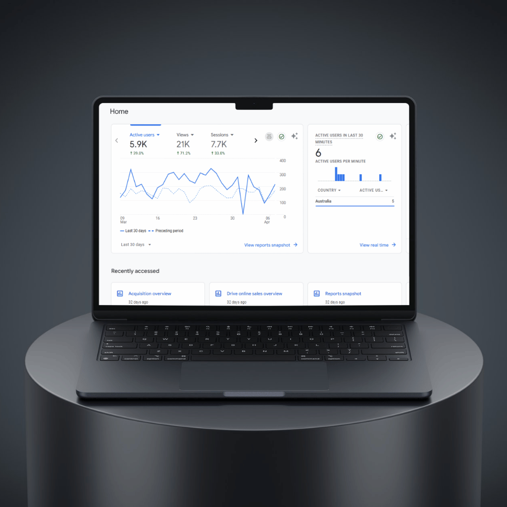 Laptop displaying analytics dashboard with graphs and user statistics on a sleek black table.